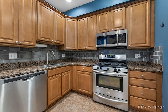 5323 S Harper Ave S Unit 1, Chicago, IL 60615 - kitchen with stainless steel appliances, backsplash, dark stone countertops, and brown cabinetry