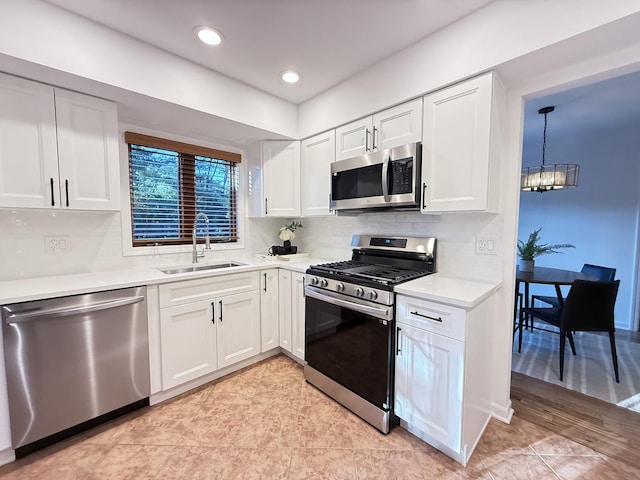6412 Redbird Ln, Crystal Lake, IL 60012 - kitchen with stainless steel appliances, a chandelier, white cabinetry, light countertops, and backsplash