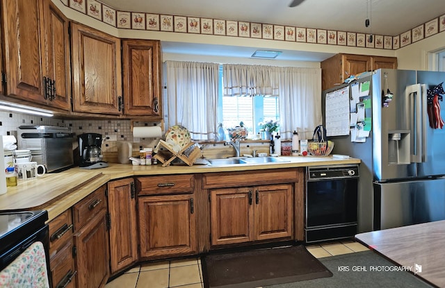 1247 Cavell Ave, Highland Park, IL 60035 - kitchen featuring black appliances, light tile patterned floors, and brown cabinetry