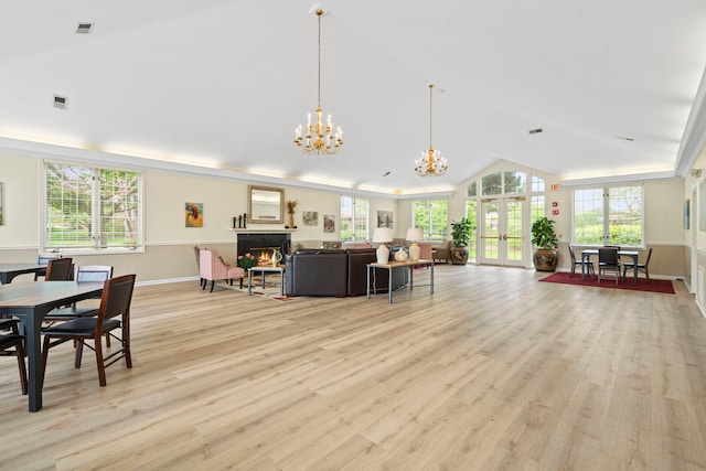 3100 Lexington Ln Unit 203, Glenview, IL 60026 - living room with a chandelier, lofted ceiling, a lit fireplace, light wood-type flooring, and french doors