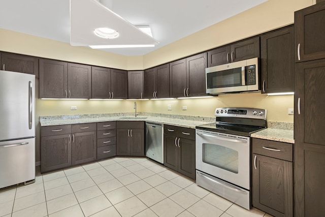 3100 Lexington Ln Unit 203, Glenview, IL 60026 - kitchen with stainless steel appliances, dark brown cabinets, light tile patterned flooring, and light stone counters