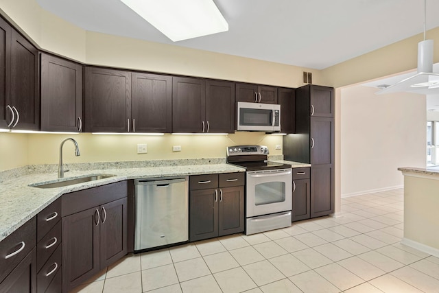 3100 Lexington Ln Unit 203, Glenview, IL 60026 - kitchen featuring appliances with stainless steel finishes, dark brown cabinetry, light tile patterned floors, and pendant lighting