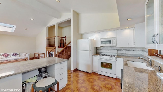 270 W Fremont Ave, Elmhurst, IL 60126 - kitchen with white appliances, white cabinetry, lofted ceiling, a skylight, and light stone counters