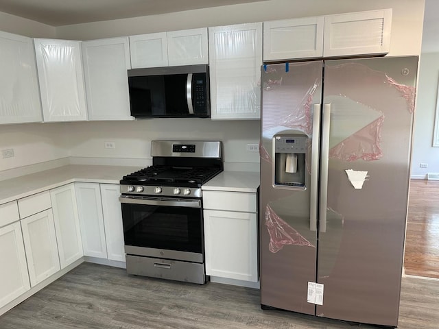 16341 Justine St, Markham, IL 60428 - kitchen featuring stainless steel appliances, light wood-style floors, white cabinets, and light countertops