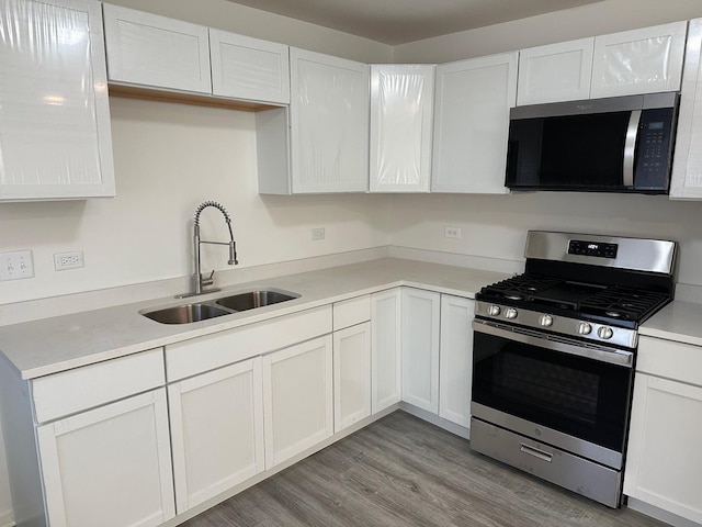 16341 Justine St, Markham, IL 60428 - kitchen featuring appliances with stainless steel finishes, light wood-style flooring, white cabinets, and light countertops