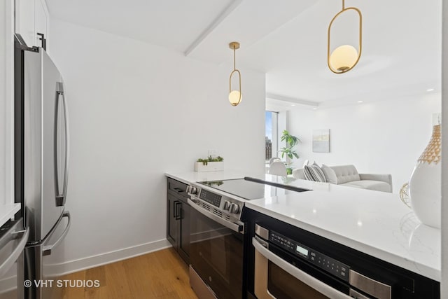 1455 N Sandburg Ter Unit 2606, Chicago, IL 60610 - kitchen with appliances with stainless steel finishes, light wood-type flooring, pendant lighting, white cabinets, and light stone counters