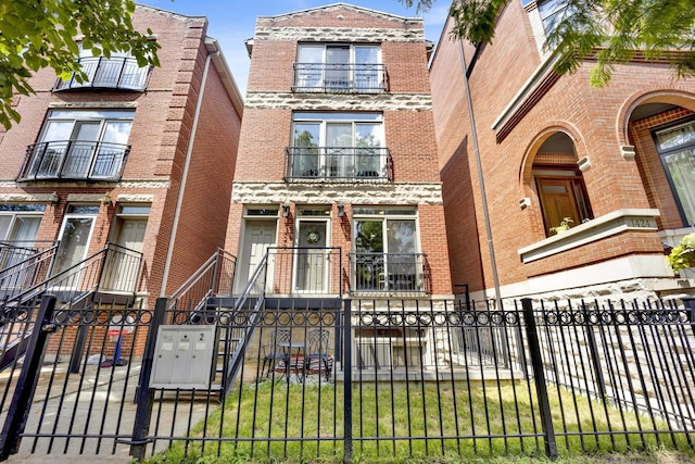 1428 W Lexington St Unit 1, Chicago, IL 60607 - view of front of house featuring brick siding, a fenced front yard, a balcony, and a gate