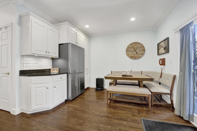 1428 W Lexington St Unit 1, Chicago, IL 60607 - kitchen with freestanding refrigerator, crown molding, dark countertops, white cabinetry, and tasteful backsplash