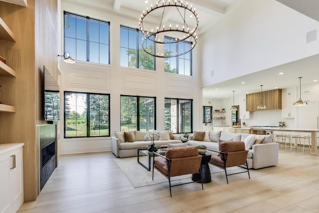 16226 Syd Creek Dr, Homer Glen, IL 60491 - living room with a high ceiling, light wood-style flooring, a fireplace, plenty of natural light, and a chandelier