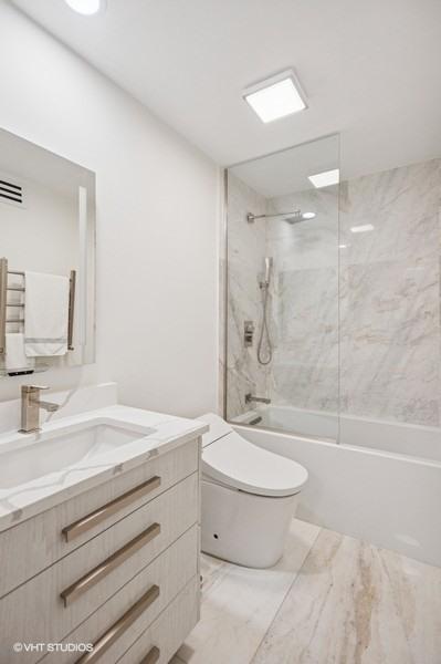 4050 Dundee Rd Unit 209, Northbrook, IL 60062 - bathroom featuring vanity, shower / tub combination, and marble look tiles