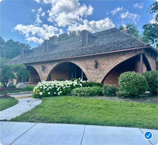 4050 Dundee Rd Unit 209, Northbrook, IL 60062 - view of side of property featuring brick siding, a yard, and a chimney