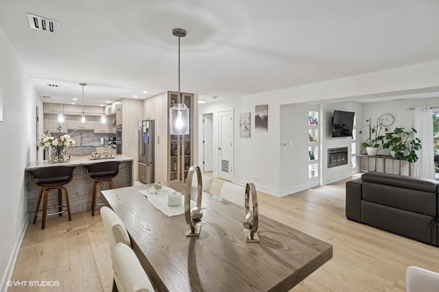 4050 Dundee Rd Unit 209, Northbrook, IL 60062 - dining area featuring light wood-style flooring, a glass covered fireplace, and recessed lighting
