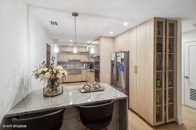 4050 Dundee Rd Unit 209, Northbrook, IL 60062 - kitchen featuring light brown cabinetry, light wood finished floors, appliances with stainless steel finishes, glass insert cabinets, and recessed lighting