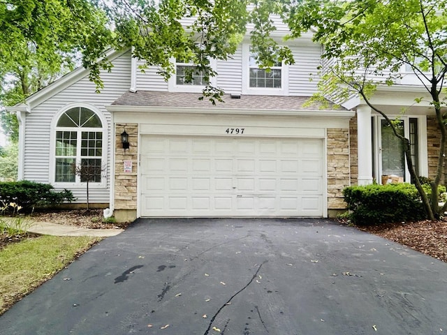 4797 Amber Cir, Hoffman Estates, IL 60192 - view of front of property featuring stone siding, asphalt driveway, a garage, and roof with shingles