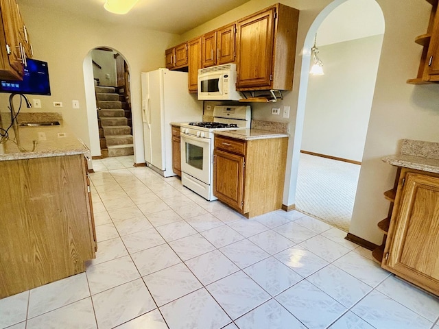 4797 Amber Cir, Hoffman Estates, IL 60192 - kitchen with white appliances, arched walkways, brown cabinetry, and light stone countertops