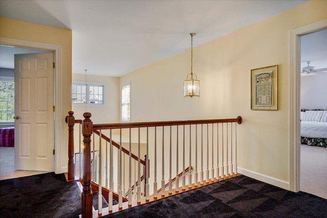 1781 Aberdeen Dr, Glenview, IL 60025 - hallway with dark carpet, an upstairs landing, and a chandelier