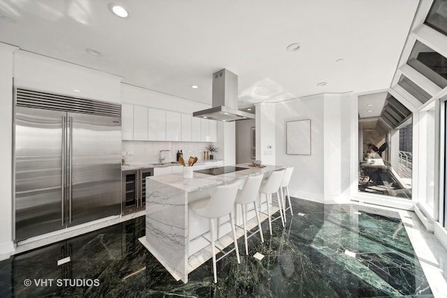 950 N Michigan Ave Unit 4904, Chicago, IL 60611 - kitchen with built in refrigerator, island range hood, wine cooler, modern cabinets, and dark marble finish floors
