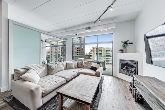 920 W Madison St Unit F8, Chicago, IL 60607 - living room featuring rail lighting, light wood finished floors, and a glass covered fireplace