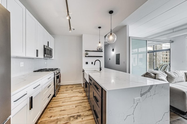 920 W Madison St Unit F8, Chicago, IL 60607 - kitchen with stainless steel appliances, open floor plan, white cabinetry, decorative backsplash, and light stone counters