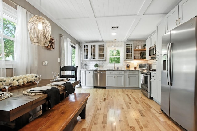 40474 N Glendale Ave, Beach Park, IL 60099 - kitchen featuring appliances with stainless steel finishes, light stone counters, decorative backsplash, light wood-style flooring, and a chandelier