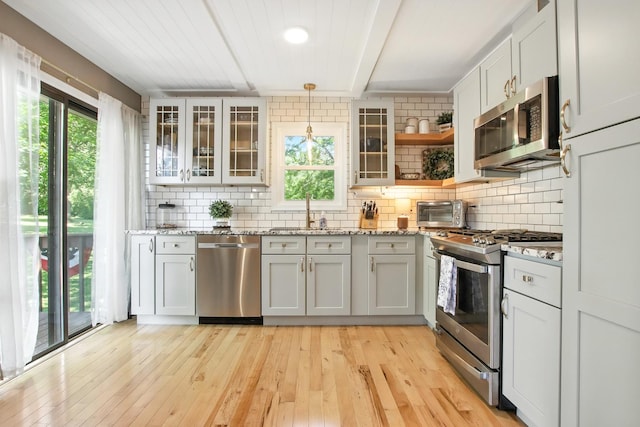 40474 N Glendale Ave, Beach Park, IL 60099 - kitchen featuring appliances with stainless steel finishes, backsplash, light wood-type flooring, light stone countertops, and beamed ceiling