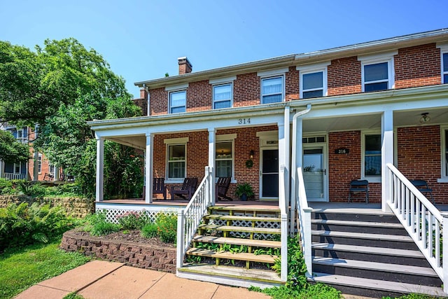 314 Elk St, Galena, IL 61036 - view of front of home with brick siding, a chimney, and a porch
