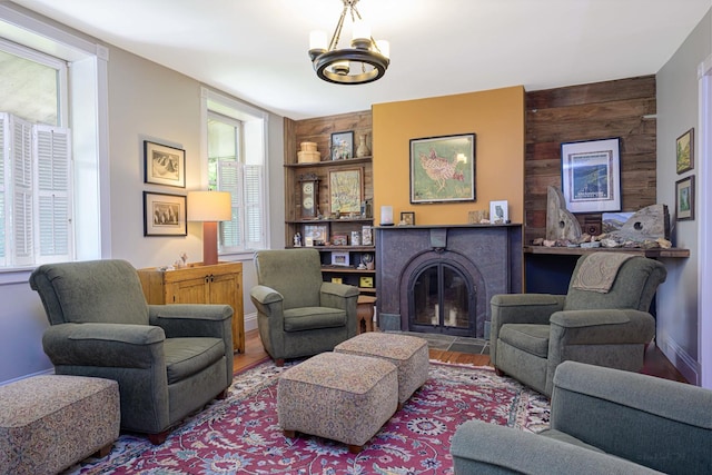 314 Elk St, Galena, IL 61036 - living area featuring a glass covered fireplace, a chandelier, wood walls, and wood finished floors