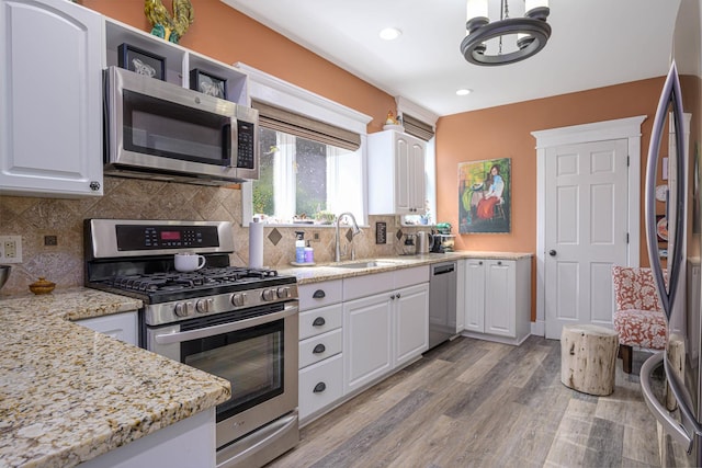 314 Elk St, Galena, IL 61036 - kitchen with appliances with stainless steel finishes, white cabinets, decorative backsplash, light wood-style floors, and recessed lighting