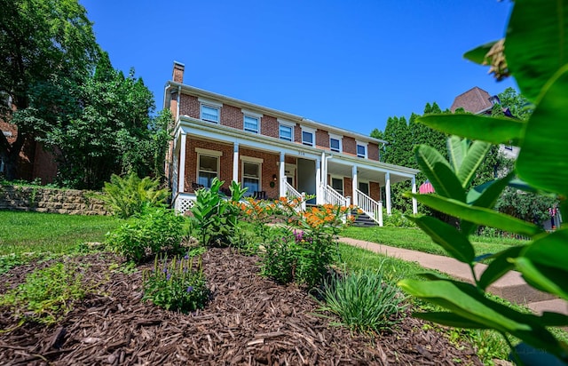314 Elk St, Galena, IL 61036 - view of front of home featuring brick siding, a porch, and a chimney