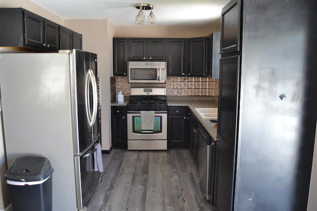 707 Omaha Ave, Lincoln, IL 62656 - kitchen featuring appliances with stainless steel finishes, dark wood-style flooring, and backsplash