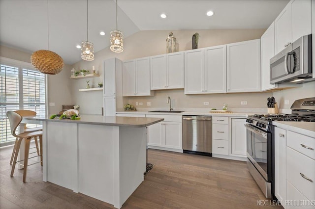 1126 Mandalay Ln Unit 1126, Bolingbrook, IL 60490 - kitchen featuring stainless steel appliances, vaulted ceiling, white cabinetry, light countertops, and a center island