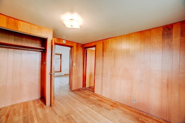 2371 N 3100 E Rd, Donovan, IL 60931 - unfurnished bedroom with light wood-type flooring, a closet, wooden walls, and a baseboard radiator