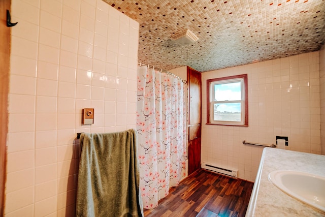 2371 N 3100 E Rd, Donovan, IL 60931 - full bathroom featuring a baseboard heating unit, wood finished floors, vanity, a shower with curtain, and tile walls