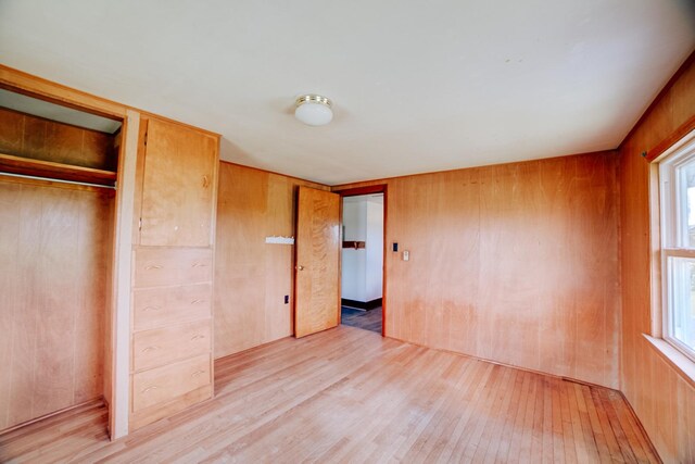 2371 N 3100 E Rd, Donovan, IL 60931 - unfurnished bedroom featuring light wood-type flooring, multiple windows, wooden walls, and a closet