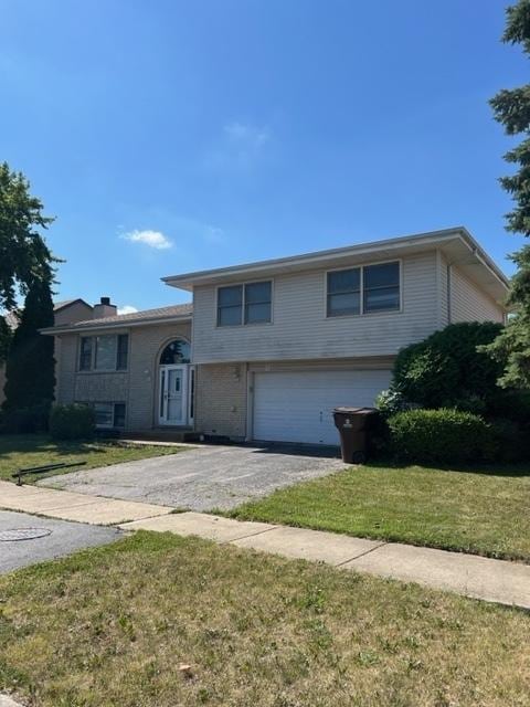 4525 Jefferson Dr, Richton Park, IL 60471 - view of front of house with an attached garage, asphalt driveway, a front lawn, and a chimney