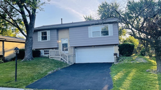 8027 Northway Dr, Hanover Park, IL 60133 - split foyer home featuring a garage, asphalt driveway, a front lawn, and brick siding