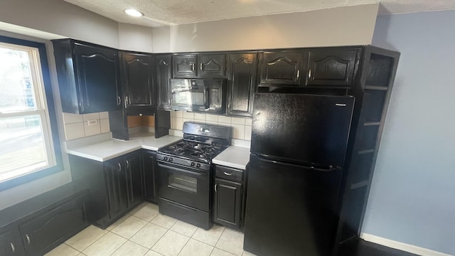 8027 Northway Dr, Hanover Park, IL 60133 - kitchen featuring black appliances, light countertops, healthy amount of natural light, decorative backsplash, and a textured ceiling