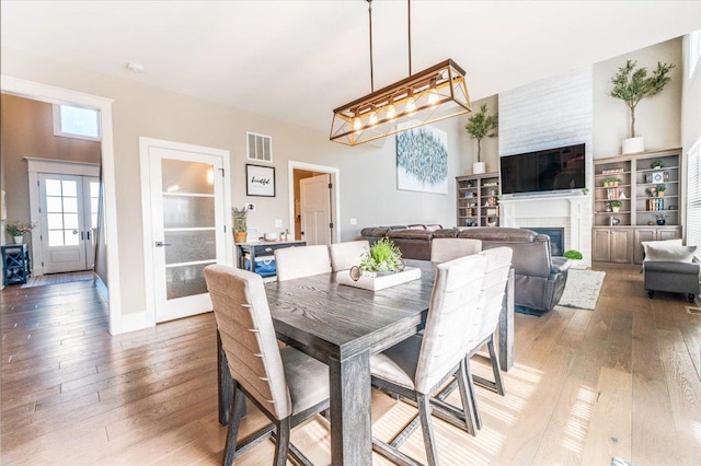 1504 Jacobs Blvd, Champaign, IL 61822 - dining space with light wood-type flooring, a fireplace, and french doors