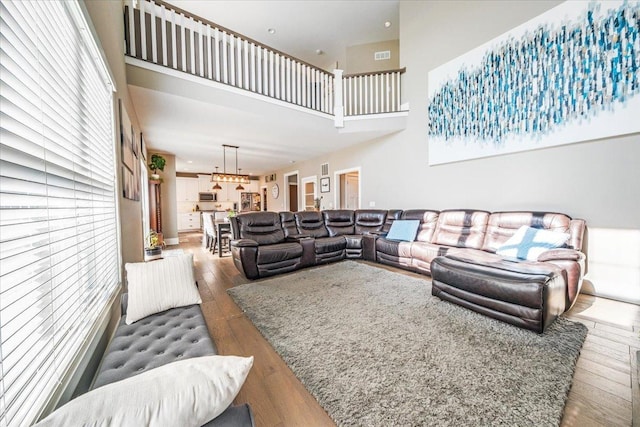 1504 Jacobs Blvd, Champaign, IL 61822 - living room featuring hardwood / wood-style flooring, a high ceiling, a chandelier, and healthy amount of natural light