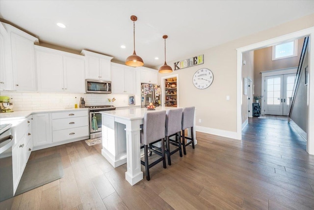 1504 Jacobs Blvd, Champaign, IL 61822 - kitchen featuring appliances with stainless steel finishes, a breakfast bar, wood finished floors, a kitchen island, and decorative backsplash
