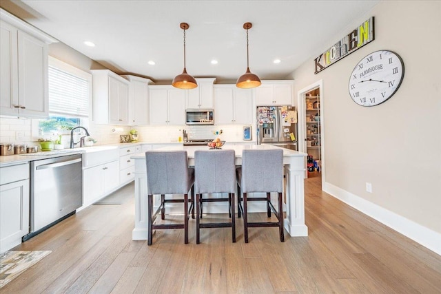1504 Jacobs Blvd, Champaign, IL 61822 - kitchen with appliances with stainless steel finishes, decorative backsplash, light wood-style floors, a kitchen breakfast bar, and recessed lighting