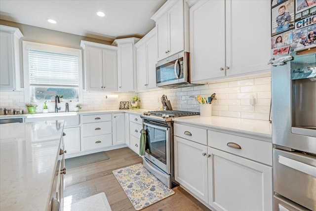 1504 Jacobs Blvd, Champaign, IL 61822 - kitchen with appliances with stainless steel finishes, white cabinetry, tasteful backsplash, light wood-style floors, and recessed lighting