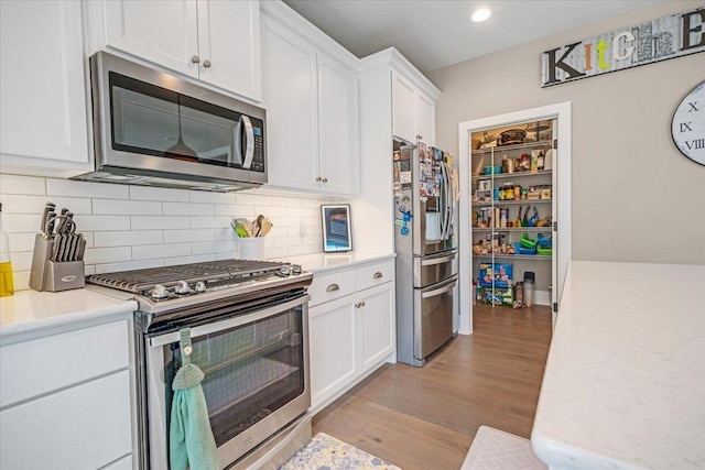 1504 Jacobs Blvd, Champaign, IL 61822 - kitchen with stainless steel appliances, light countertops, white cabinetry, light wood-style flooring, and recessed lighting