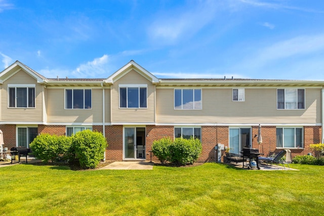 630 Legend Ln, Mchenry, IL 60050 - rear view of house featuring a lawn, brick siding, and a patio area
