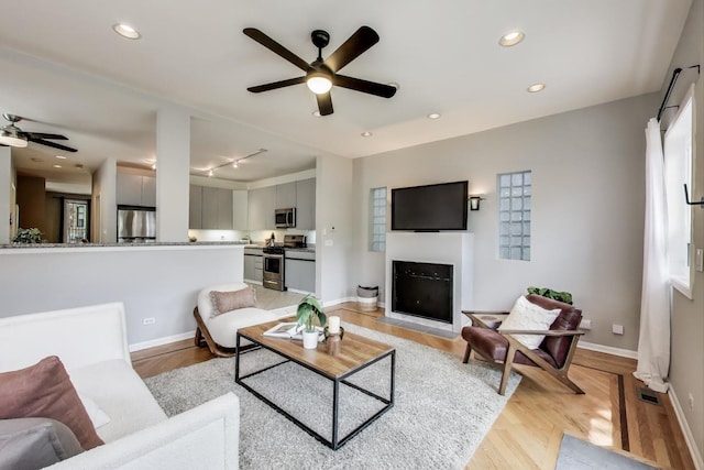 1636 N Leavitt St, Chicago, IL 60647 - living room featuring a ceiling fan, light wood-type flooring, a fireplace with flush hearth, recessed lighting, and track lighting