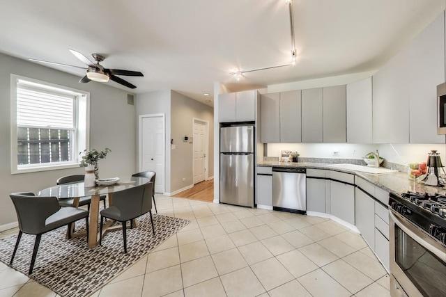 1636 N Leavitt St, Chicago, IL 60647 - kitchen with appliances with stainless steel finishes, track lighting, a ceiling fan, light tile patterned floors, and light stone counters