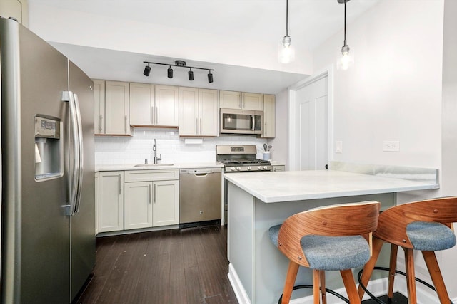 10417 Massasoit Ave, Oak Lawn, IL 60453 - kitchen featuring appliances with stainless steel finishes, dark wood-style flooring, a peninsula, light countertops, and a breakfast bar
