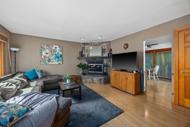 211 David Dr, Streamwood, IL 60107 - living room featuring light wood-style floors, a stone fireplace, and a ceiling fan