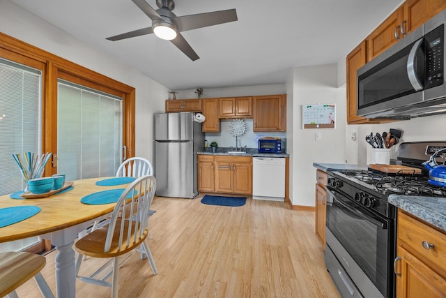 211 David Dr, Streamwood, IL 60107 - kitchen with stainless steel appliances, light wood-style floors, a ceiling fan, and brown cabinets