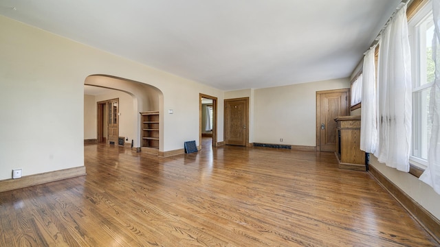 611 S Hennepin Ave, Dixon, IL 61021 - unfurnished living room with arched walkways and wood finished floors